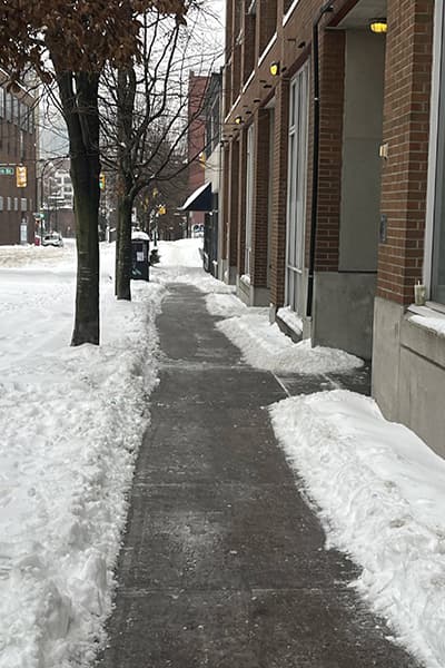 A fully cleared sidewalk in front of a building after MintClean service